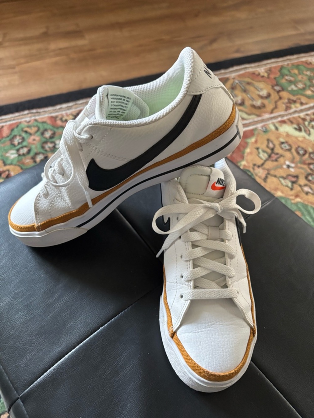 Nike White Sneakers with Black Swoosh and Gold Accent